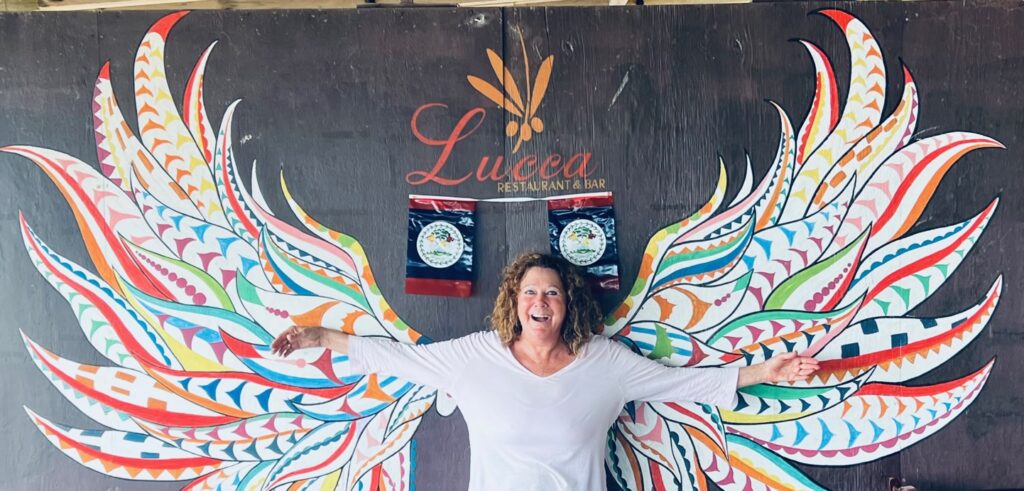 A woman posing in front of a drawing of wings